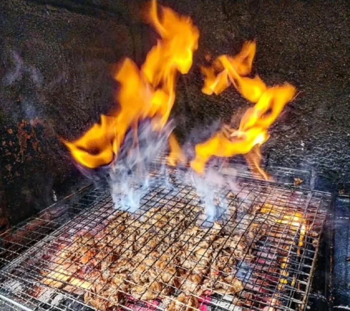 숯불 위에서 장어를 굽는 모습, 불꽃이 일고 있다