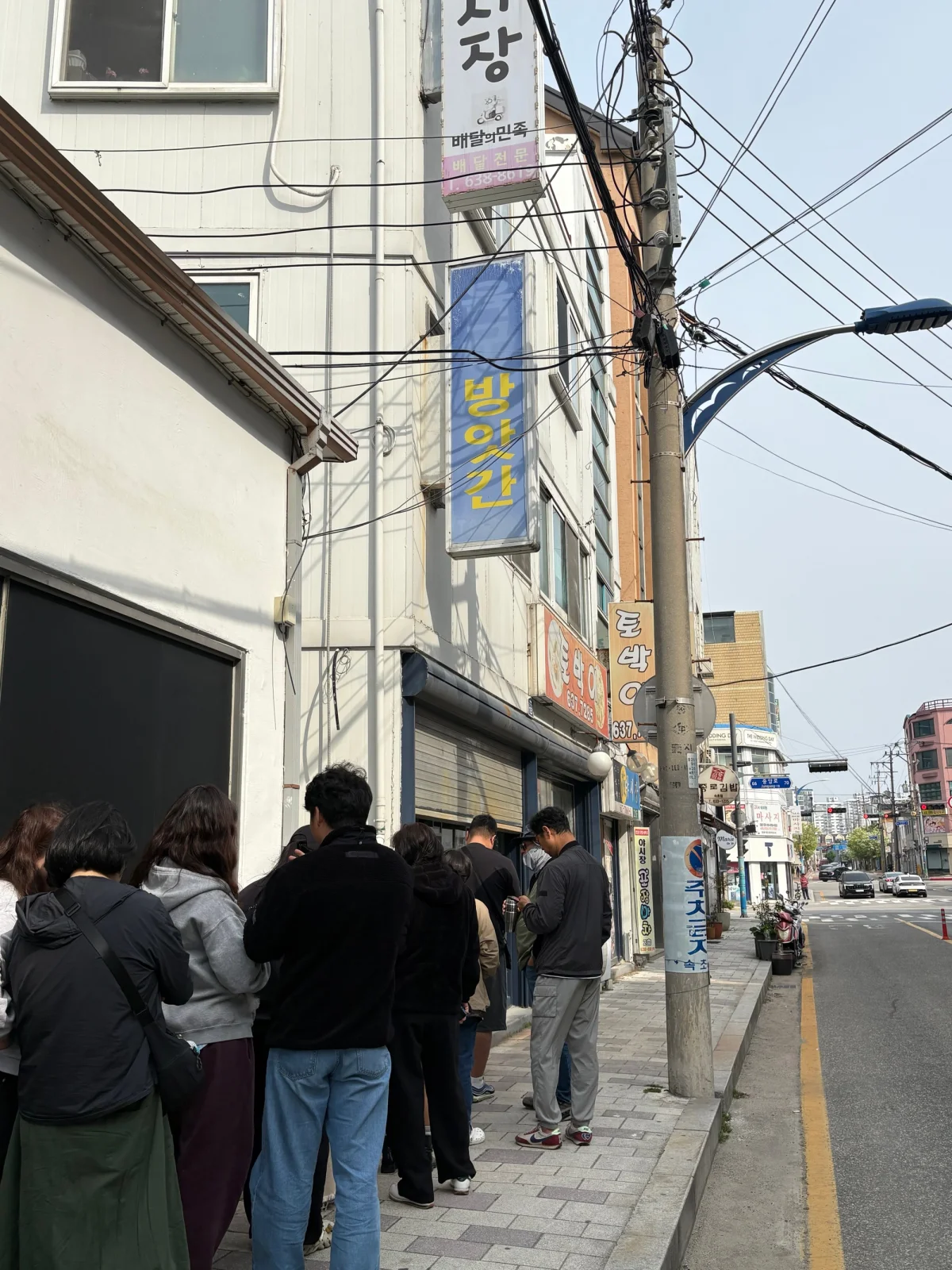 육구방앗간 매장 앞에 줄 서 있는 방문객들과 방앗간 간판
