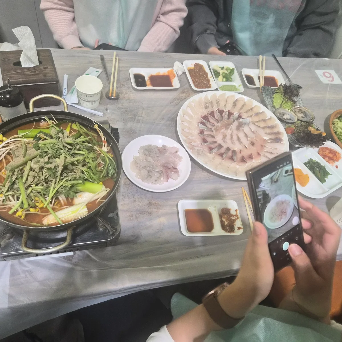 새양호 매장 좌석에서 활어회와 매운탕을 먹는 모습