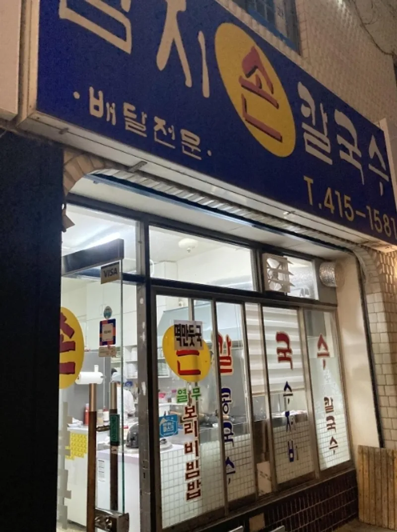 엄지손칼국수 매장 외관, 배달전문 간판과 전화번호가 보이는 입구