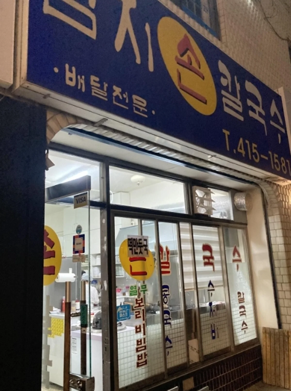 엄지손칼국수 매장 외관, 배달전문 간판과 전화번호가 보이는 입구