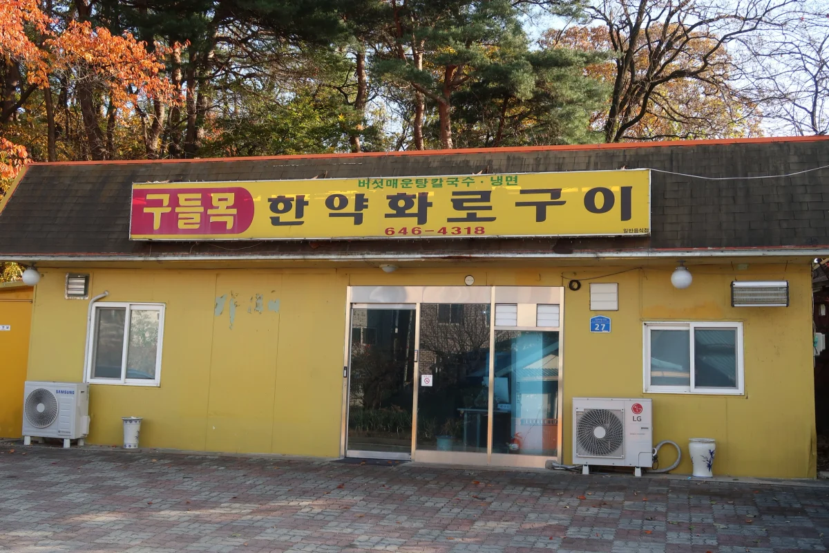 구들목 매장 외관과 노란색 벽 간판
