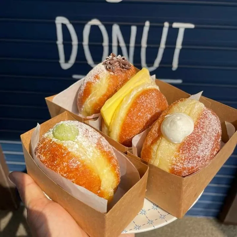 러셀도넛 도넛 4종이 담긴 종이 포장 박스와 DONUT 간판