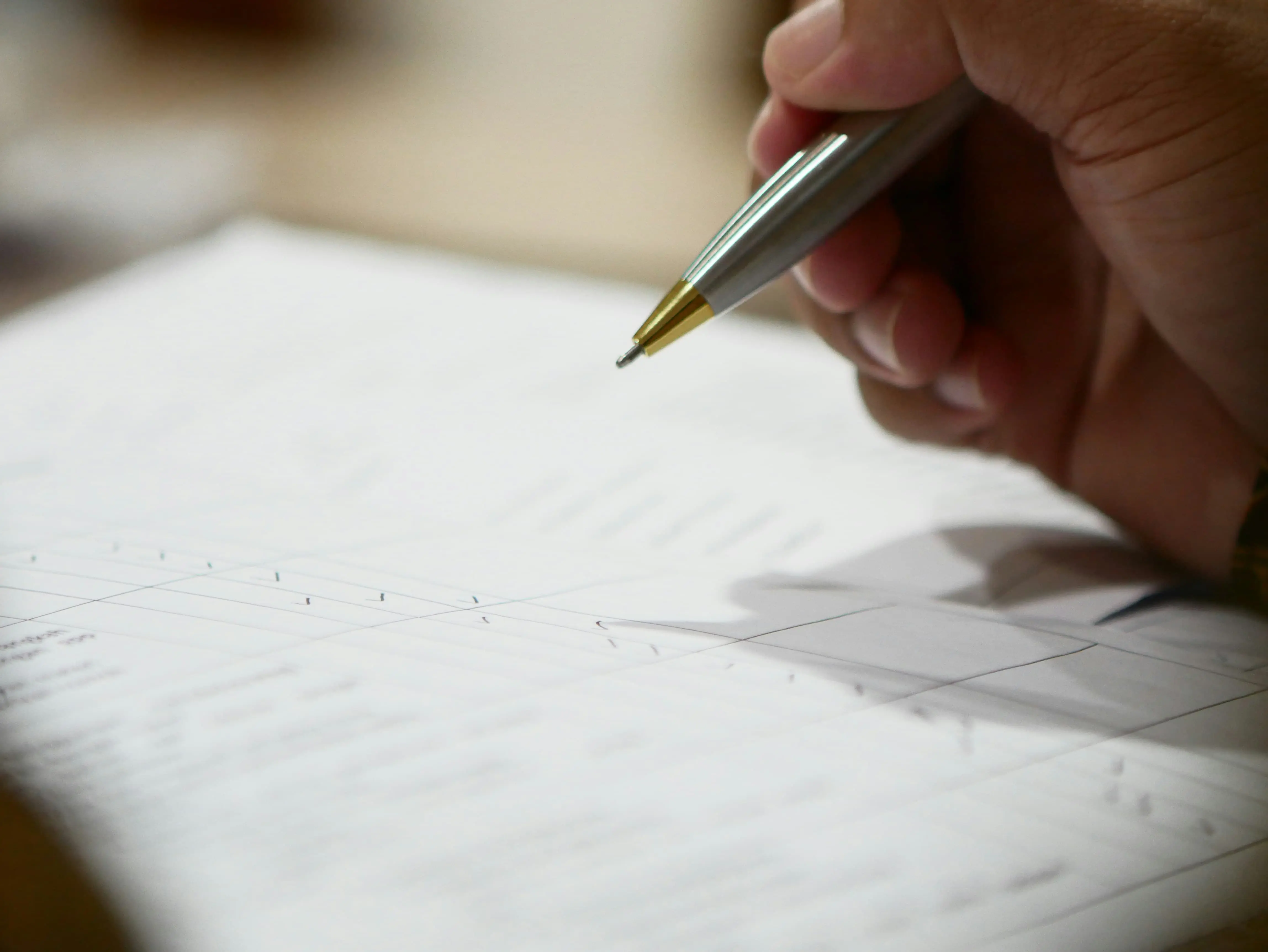 Evaluator marking a scoresheet with a pen