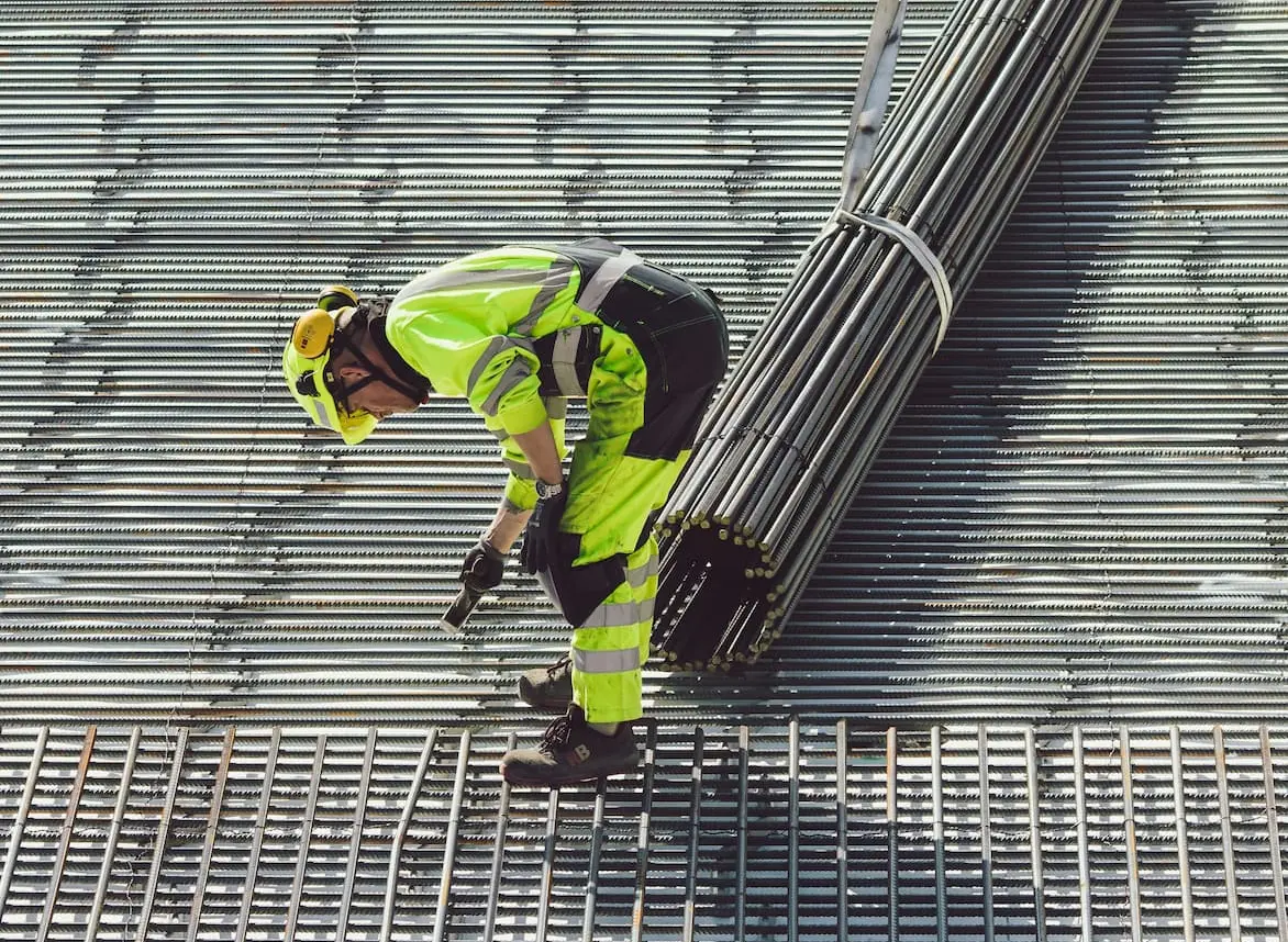 A construction worker working on a metal grate