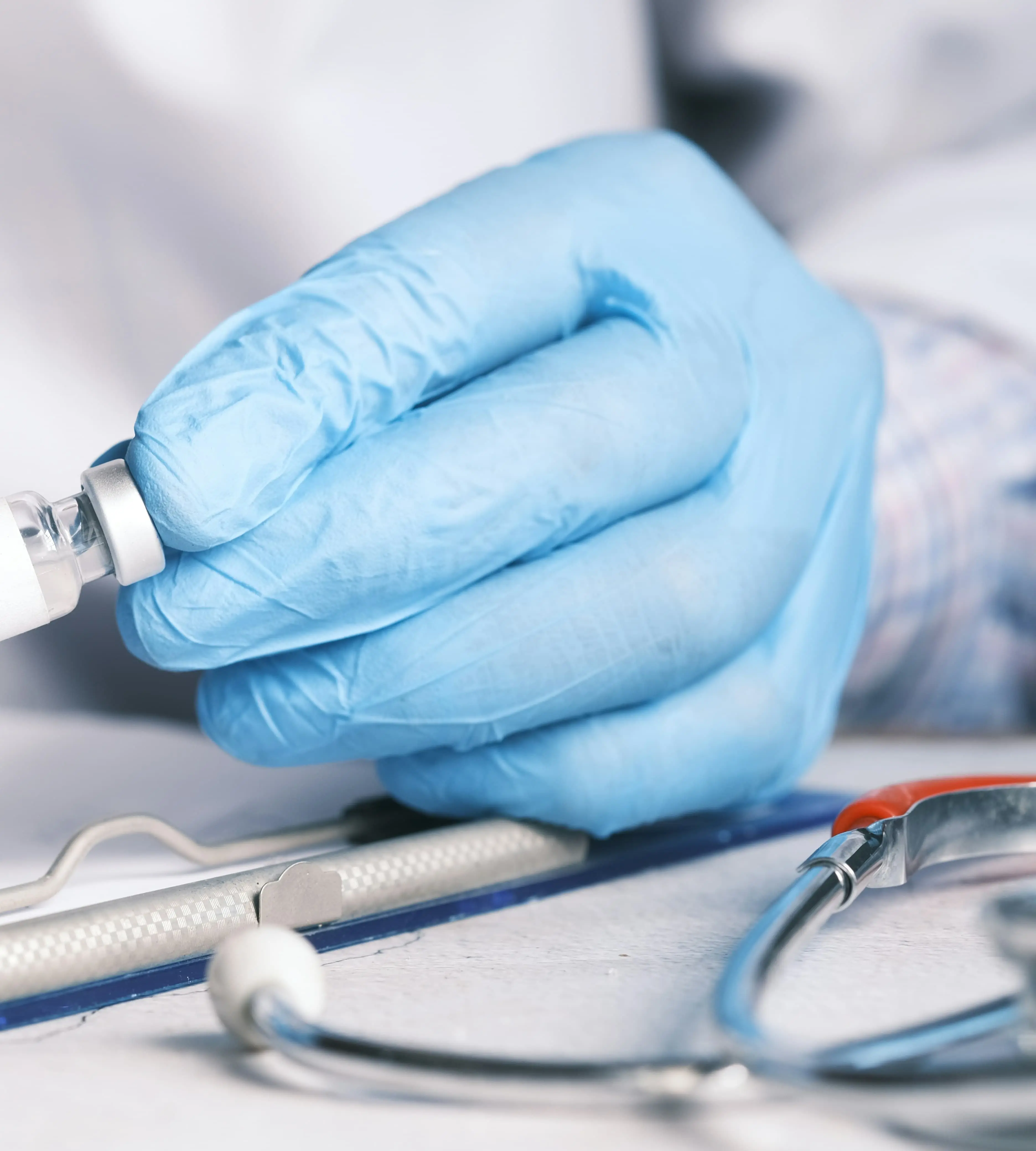 Gloved hand inspecting medication