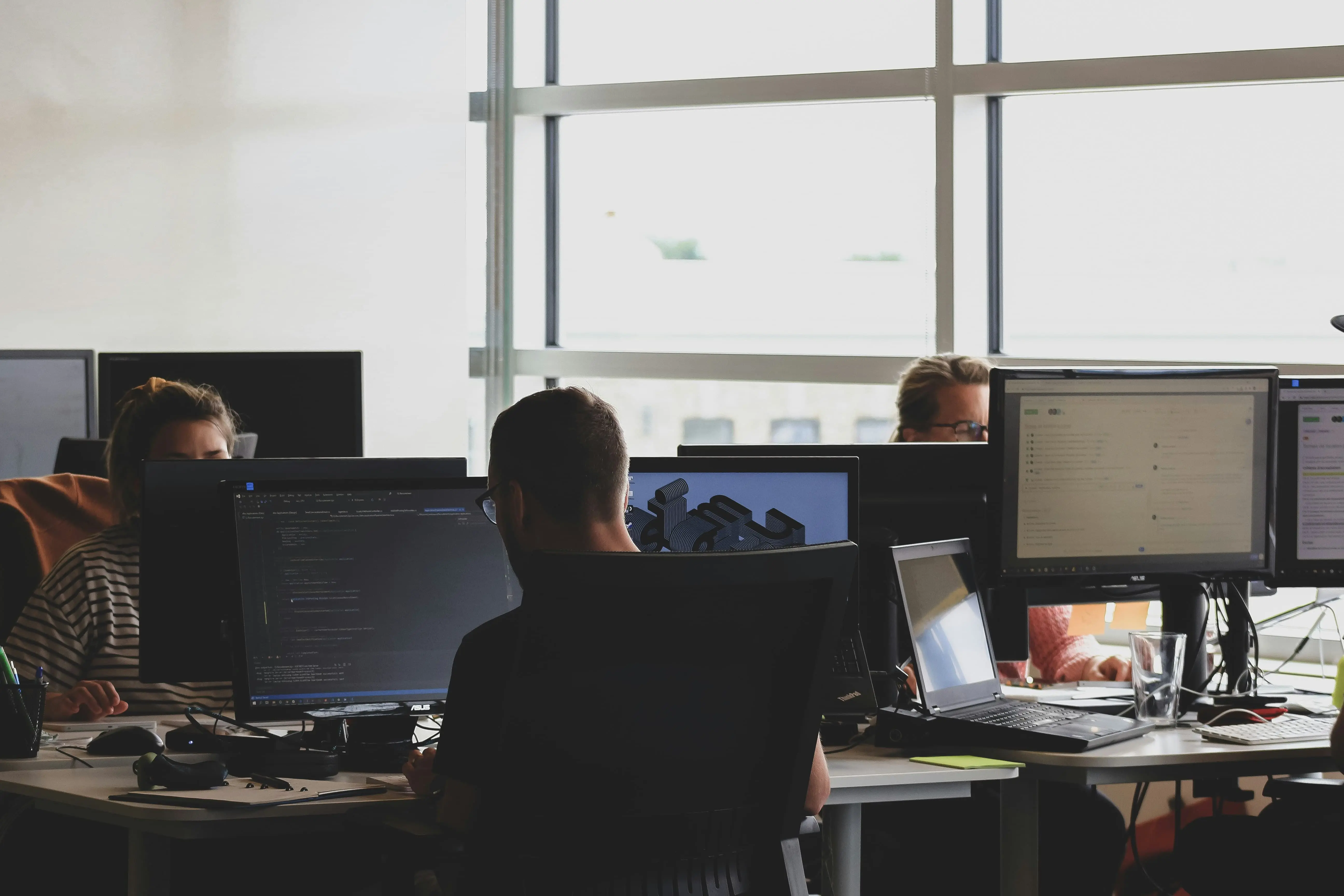 People working at computers in a modern office.