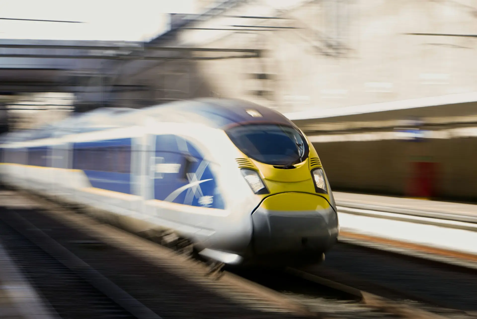 A high-speed train moves quickly past a station.