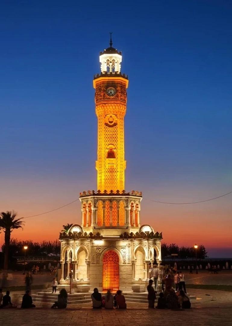 Izmir Clock Tower illuminated against a vibrant sunset sky.