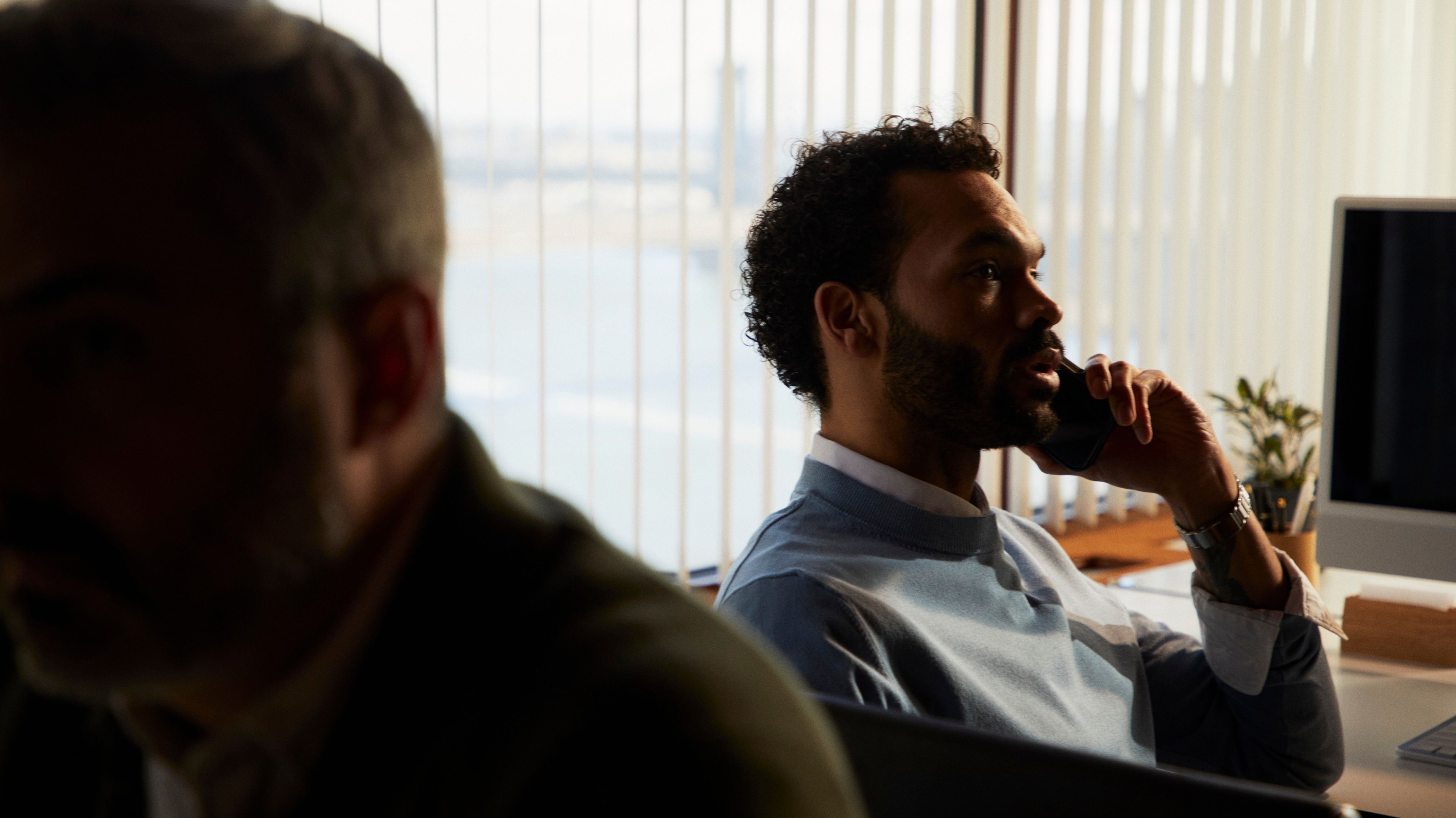 Lawyer on a phone call in a warmly-lit office