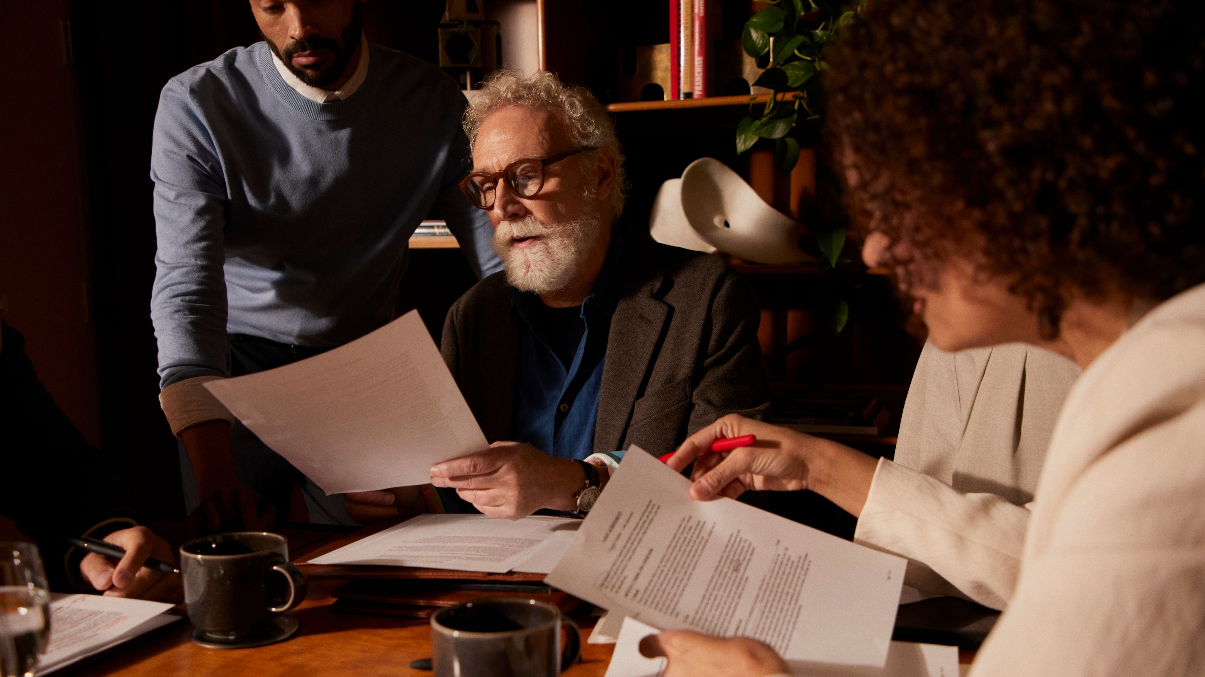Many lawyers reviewing papers in a well-lit office