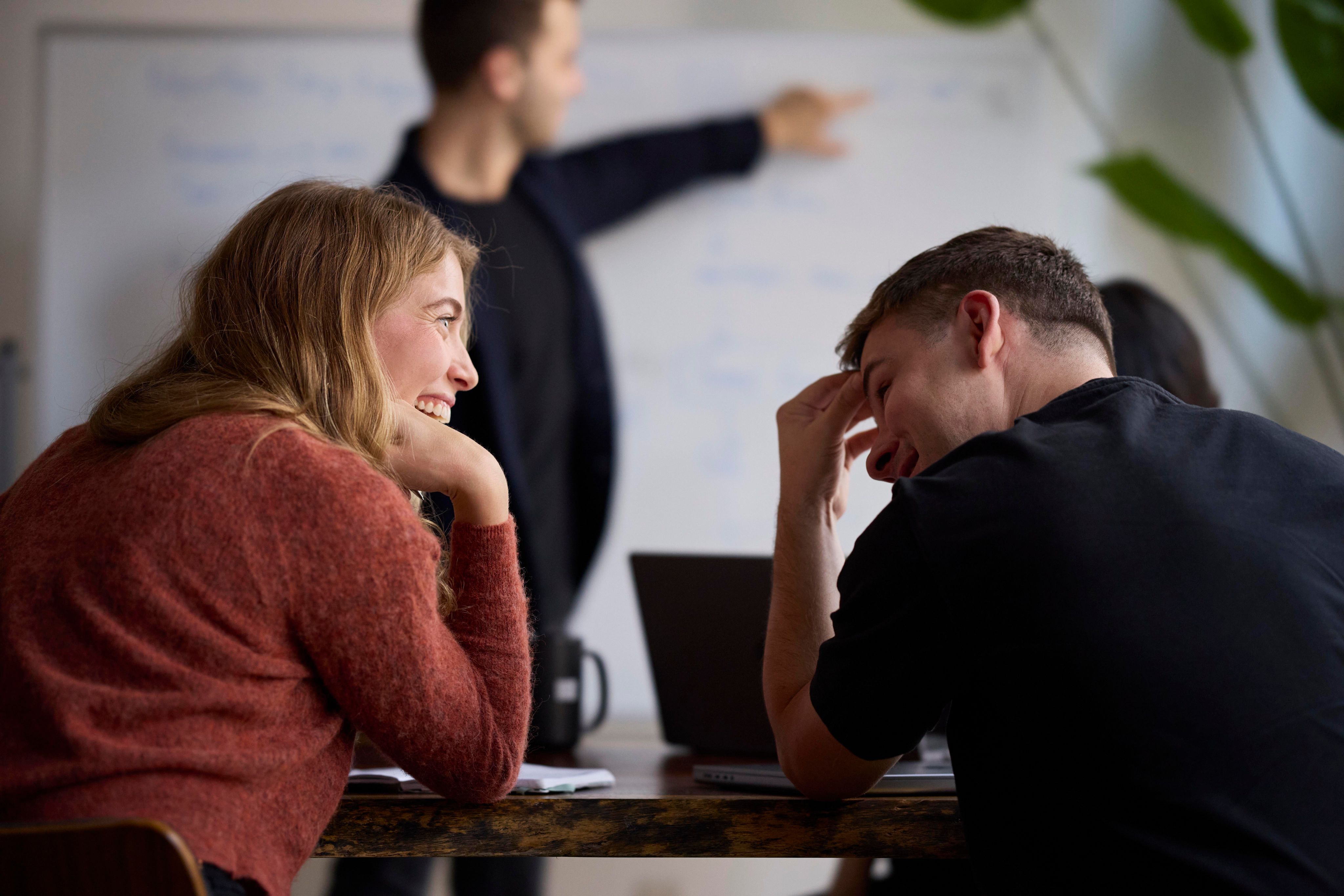 two people laughing with each other at work.