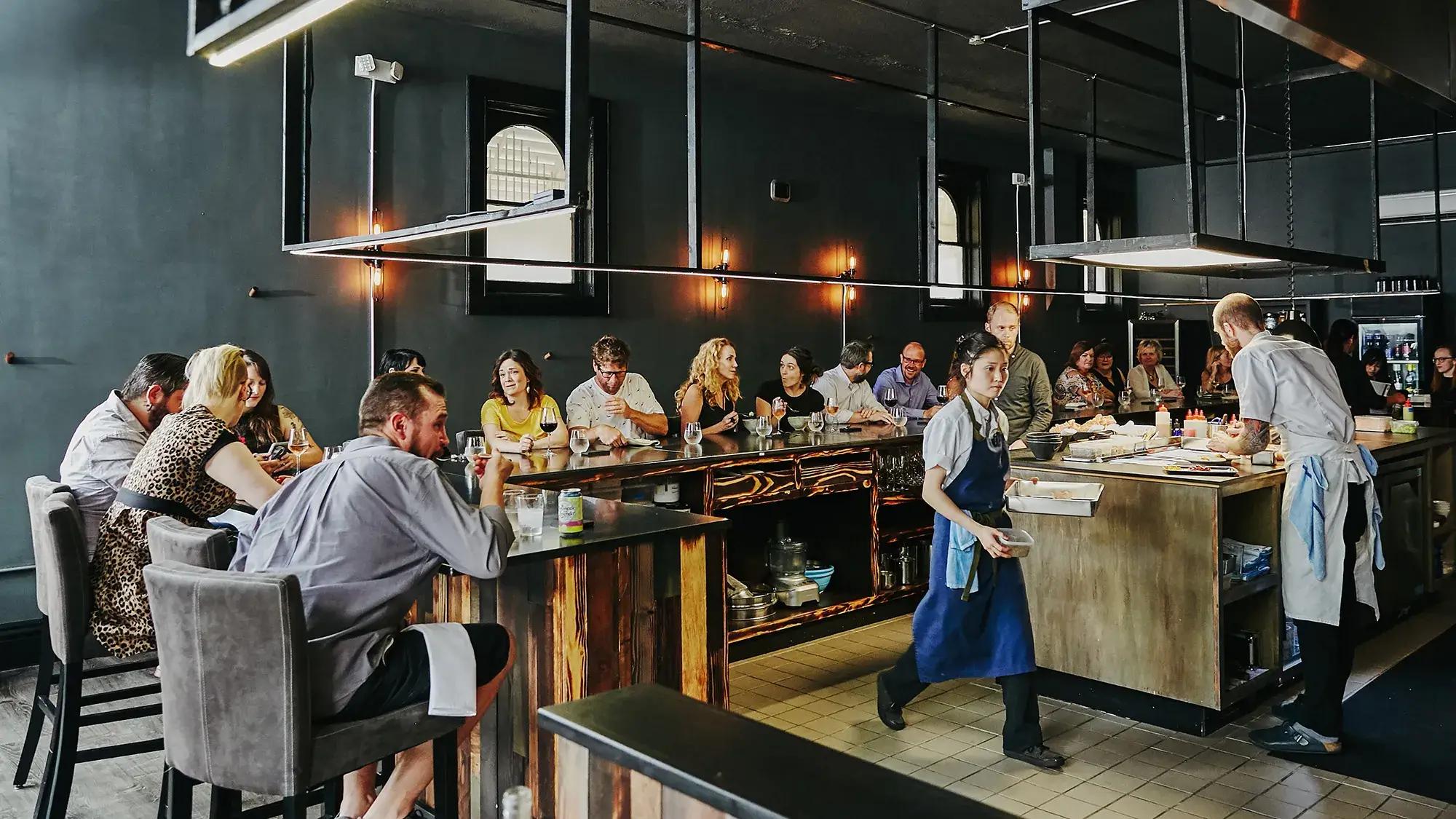 Busy restaurant atmosphere with many guests enjoying meals.