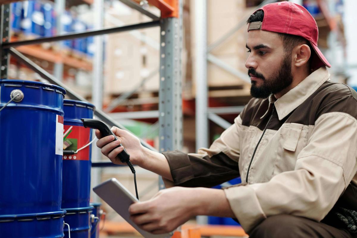 A man using a scanner in a warehouse.
