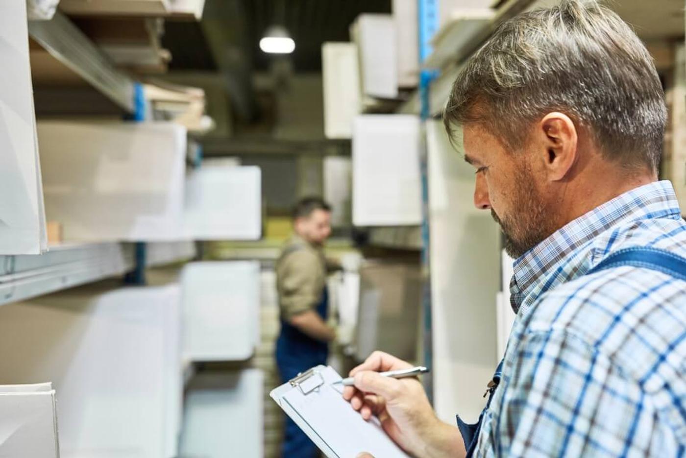 A man doing an inventory in a stock room.
