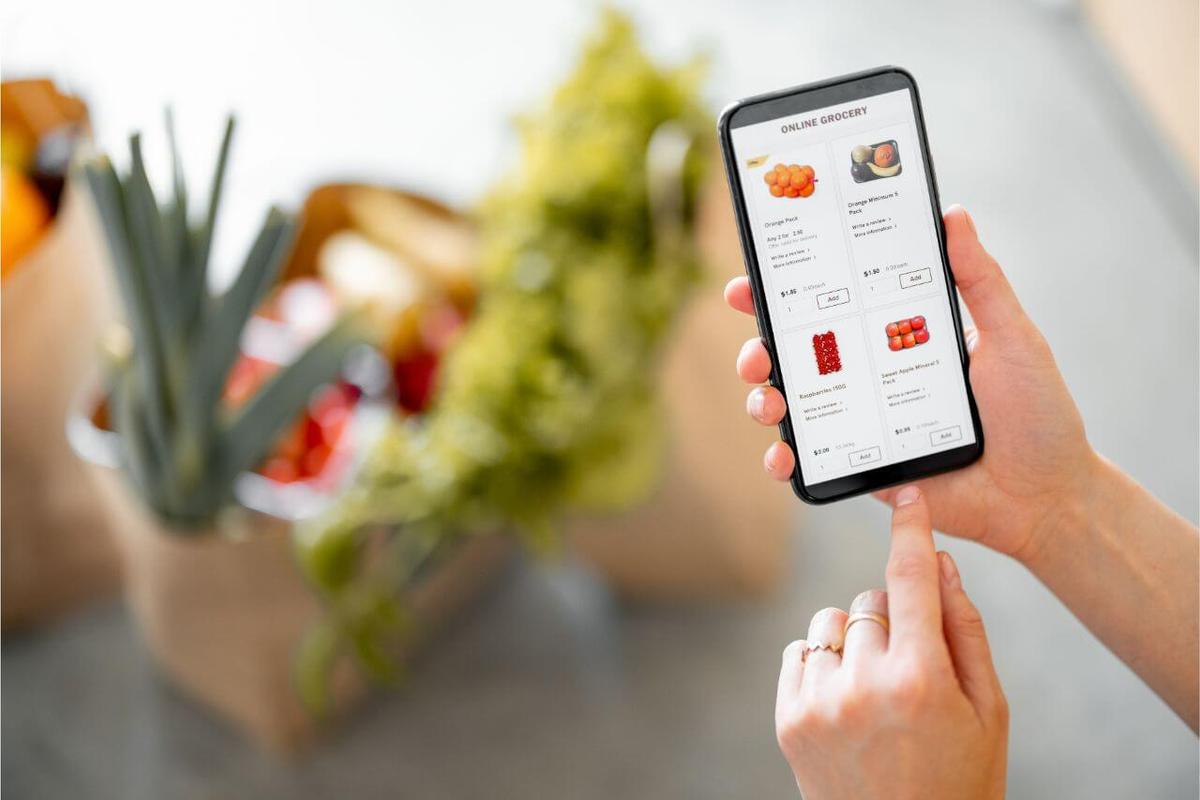 A man using a phone to order groceries online.