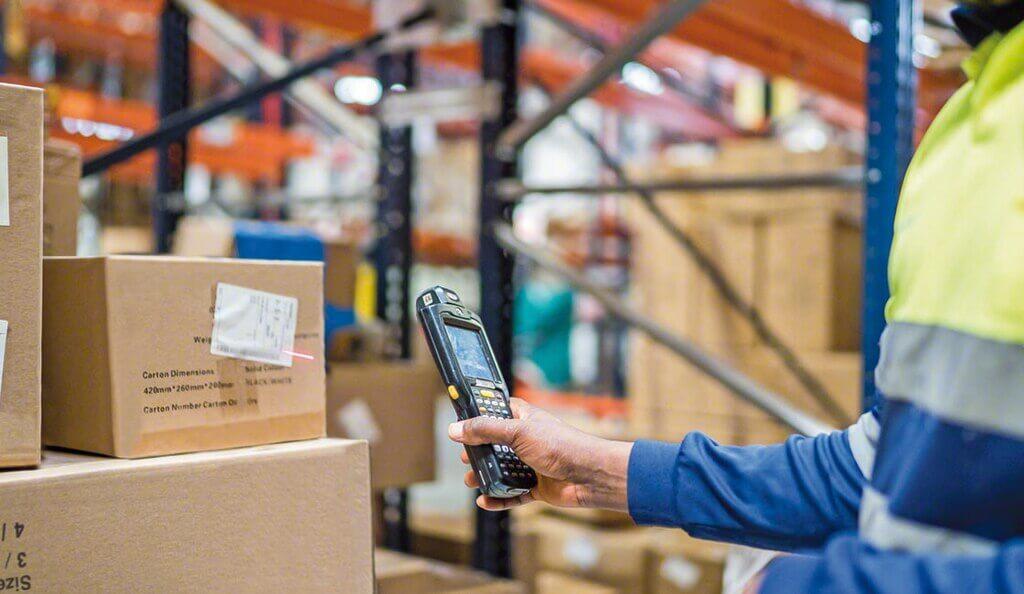 A man scanning a barcode in a warehouse.