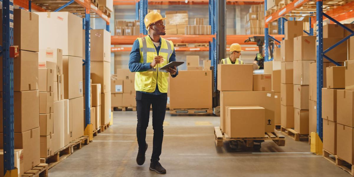 Man checking inventory with a tablet in a warehouse.