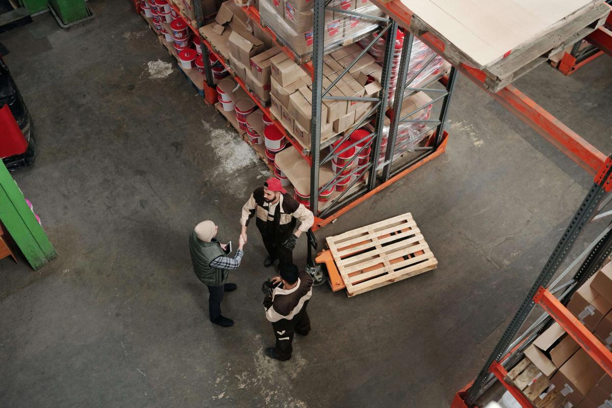 Three men discussing inside a warehouse.
