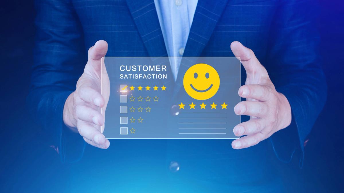 Hands of a businessman holding a happy face, representing customer satisfaction.