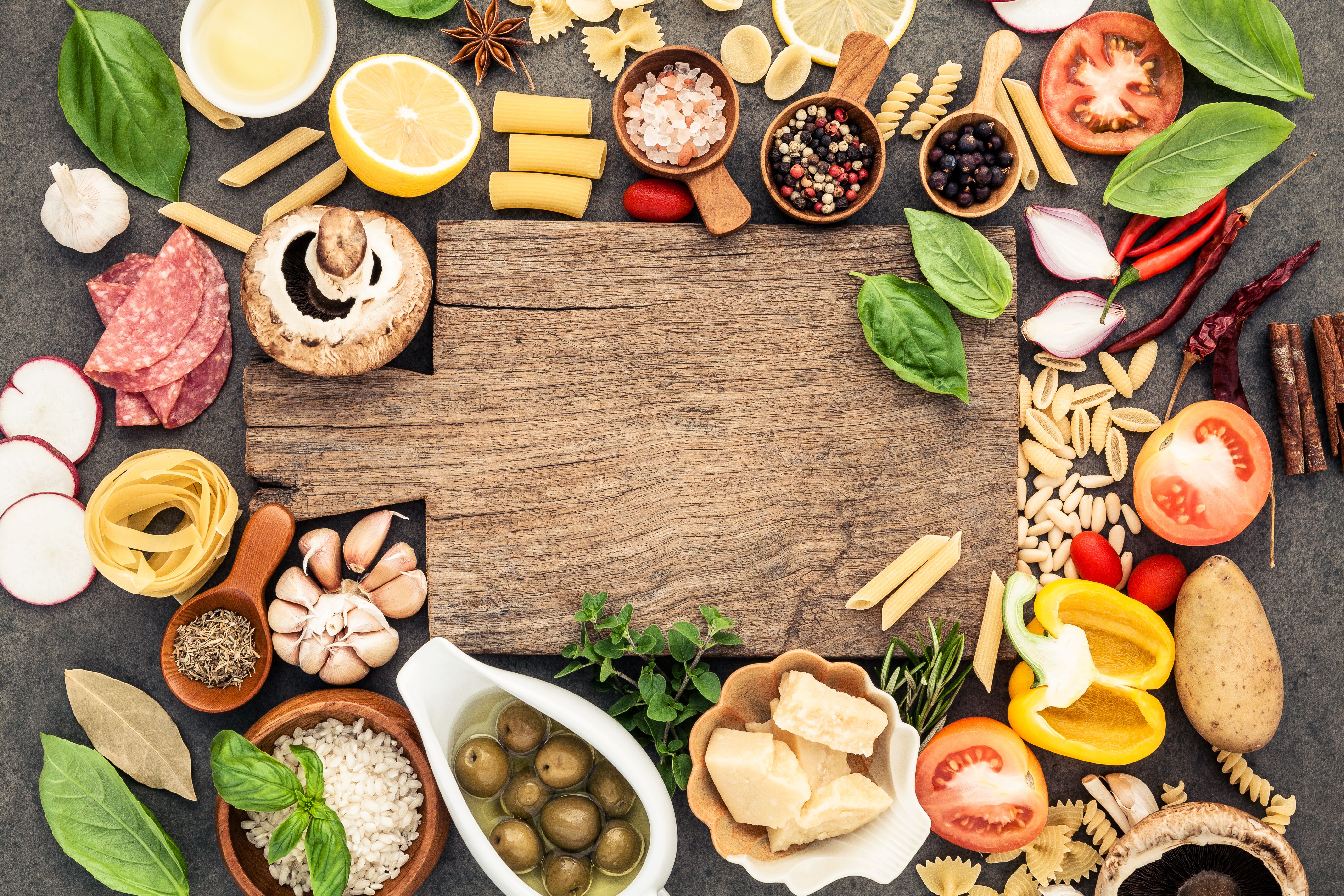 Cutting board surrounded by fresh ingredients.