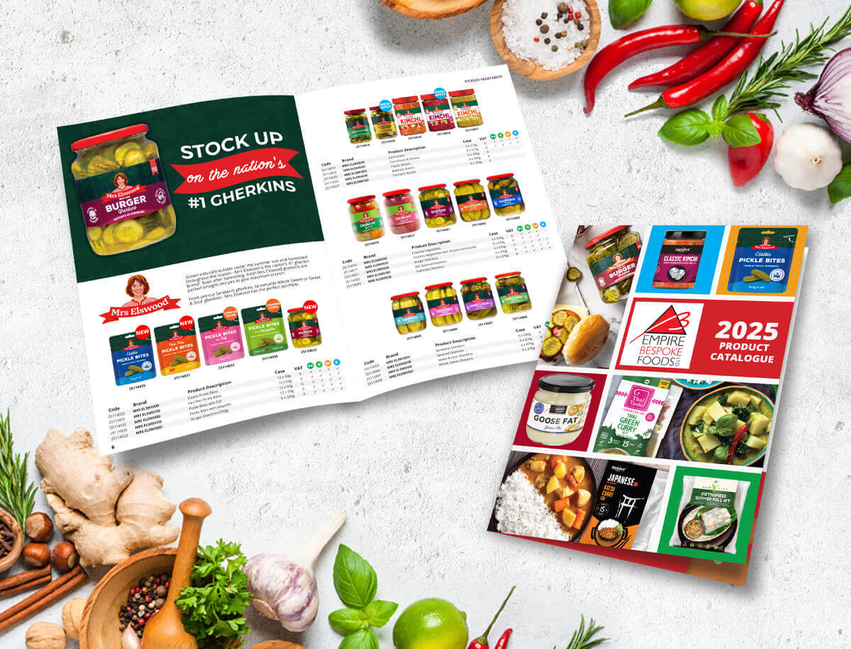 Food product catalogue spread showing pickles, sauces, and preserved goods with fresh ingredients on a kitchen-style background.