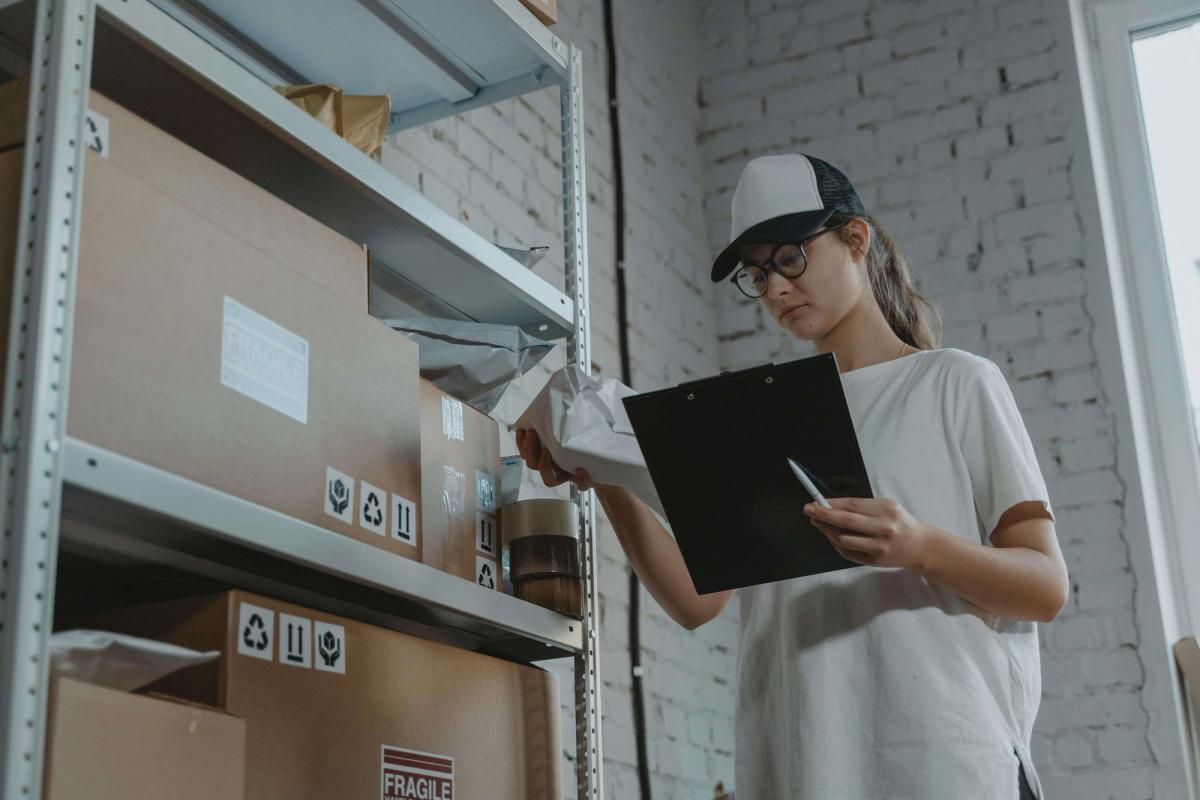 A girl taking inventory in a warehouse.