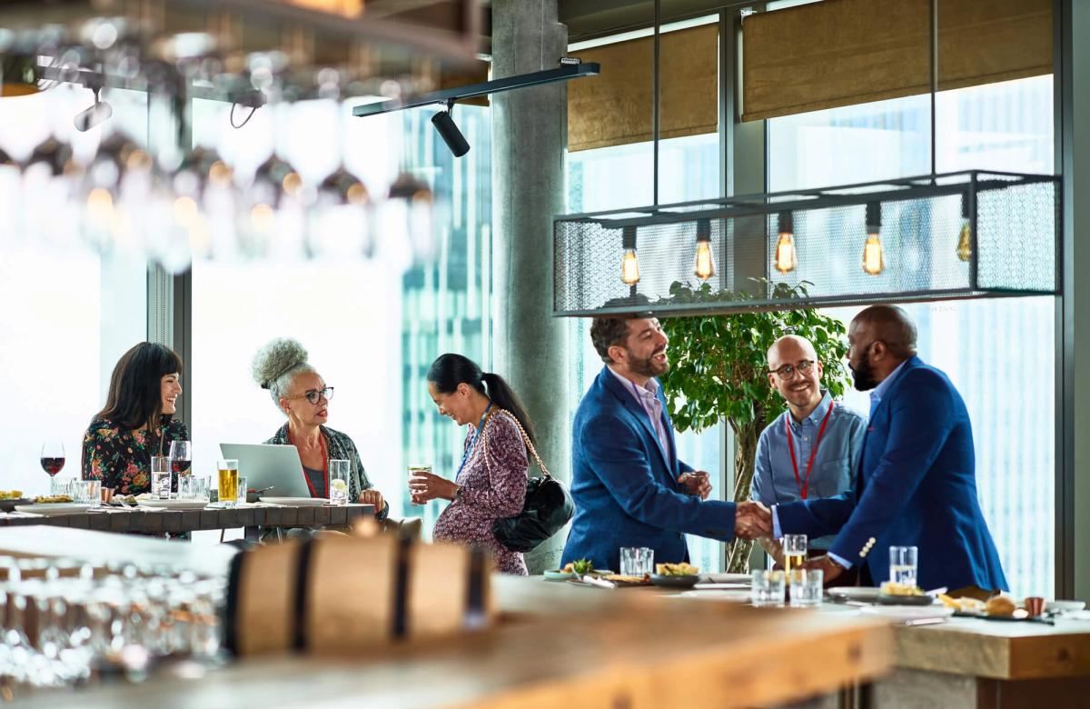 A group of people in a restaurant are chatting with each other.