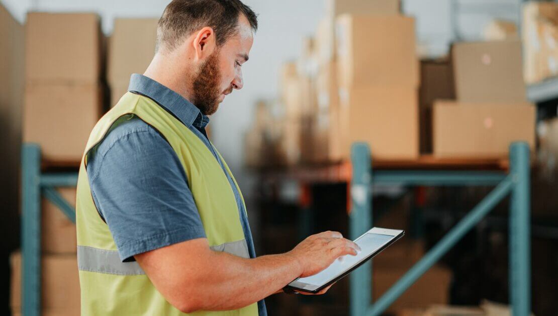 Man using a tablet in a warehouse.