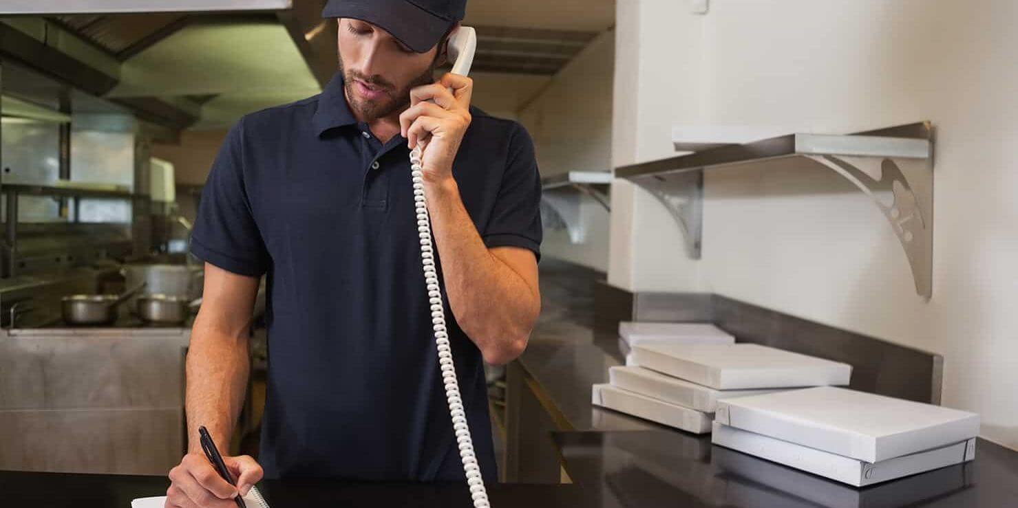 A man taking orders from the phone.