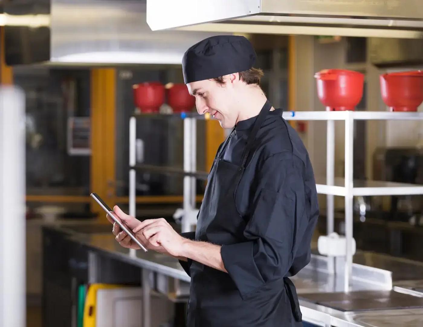 A chef holding a tablet.
