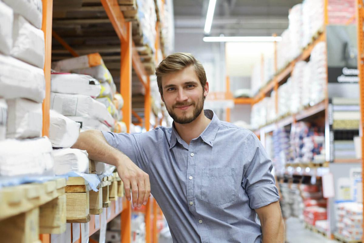 A man standing among the shelves in a warehouse.