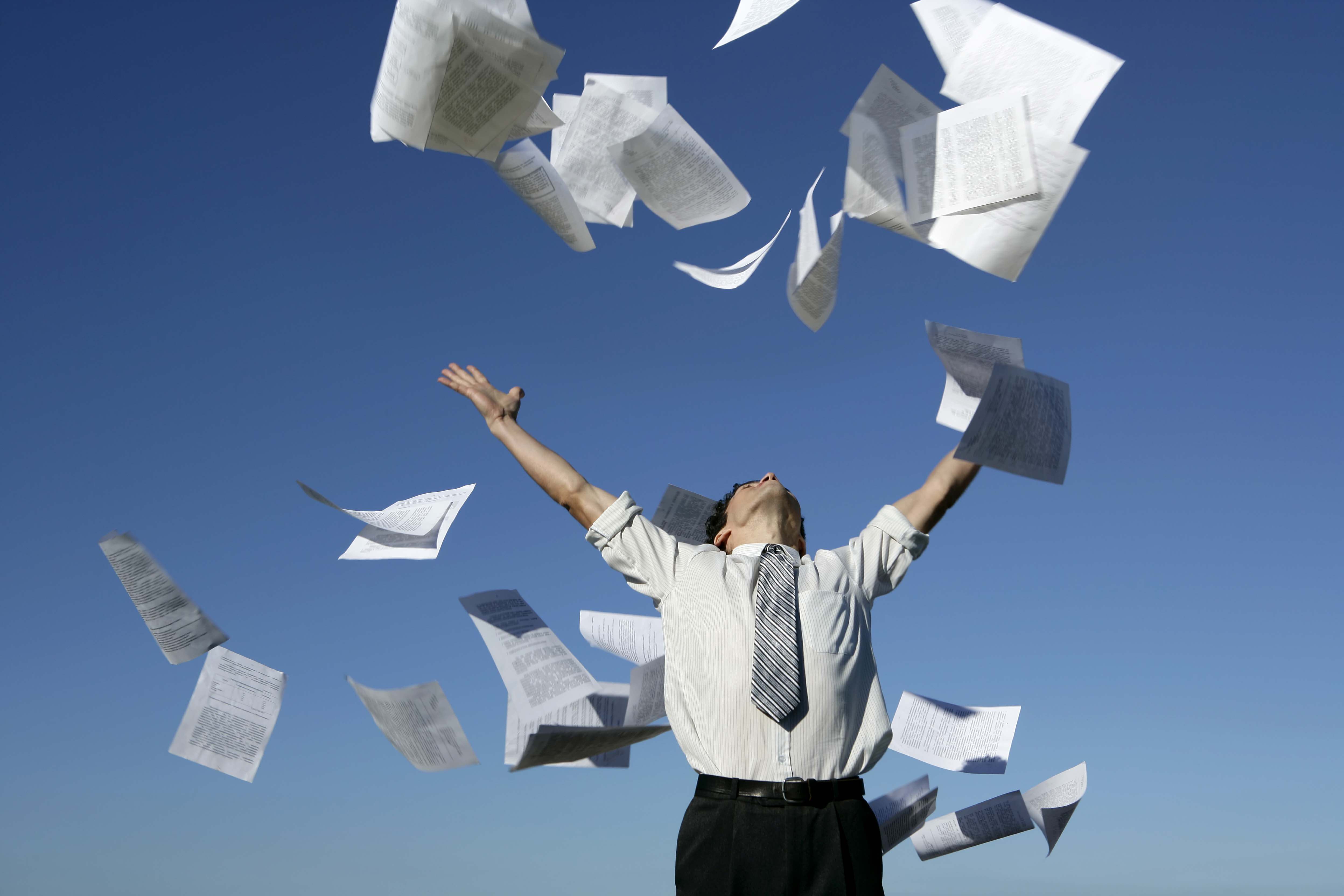 Man throwing paper documents into the air.
