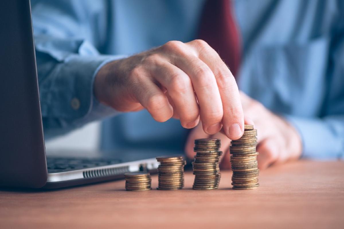 A person arranging coins on piles of coins.