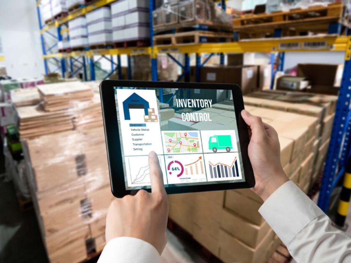 A man in a warehouse, using a tablet in tracking the inventory.