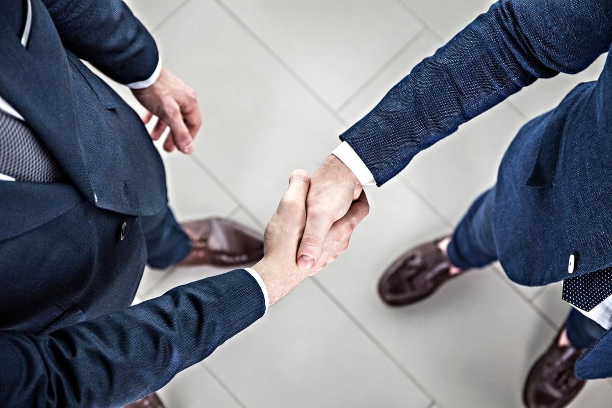 A close-up of two men shaking hands.