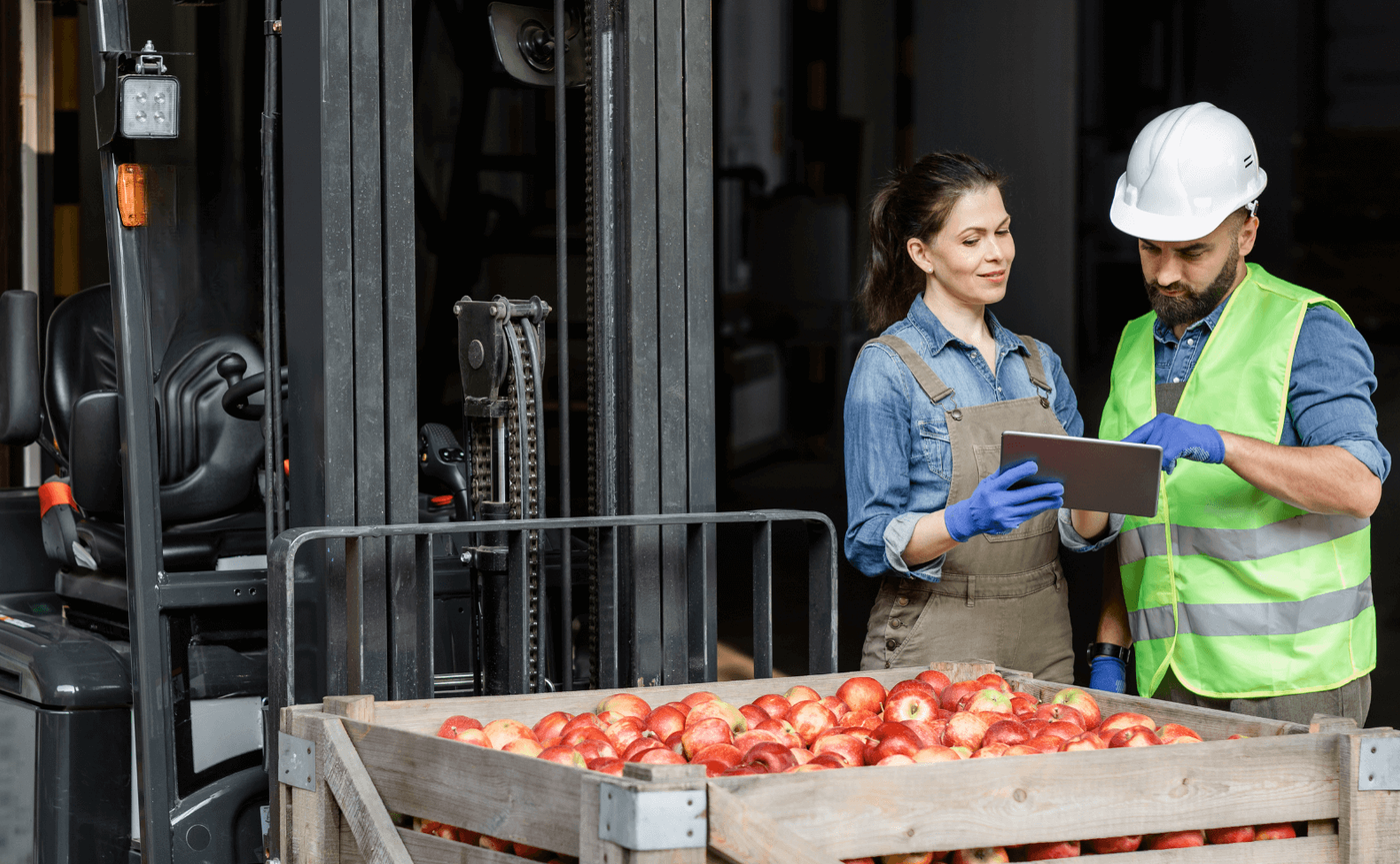Man and woman looking at a tablet and discussing in a warehouse.
