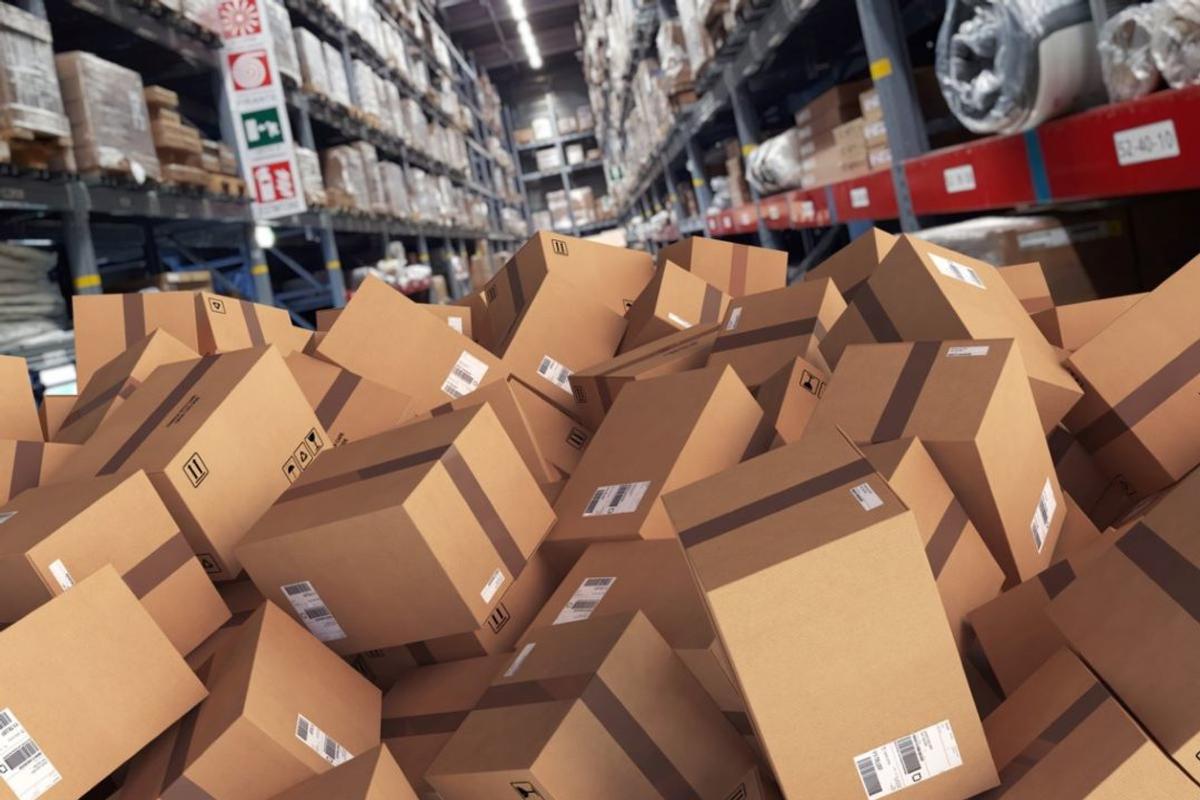 A pile of boxes in a warehouse symbolizing overstock of products.