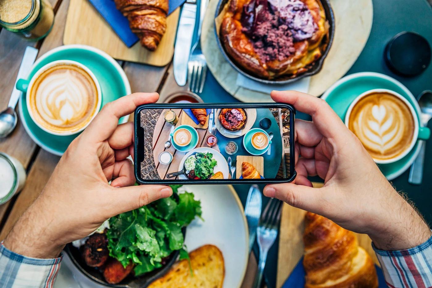 A person taking a picture of an appetising meal displayed on a table.
