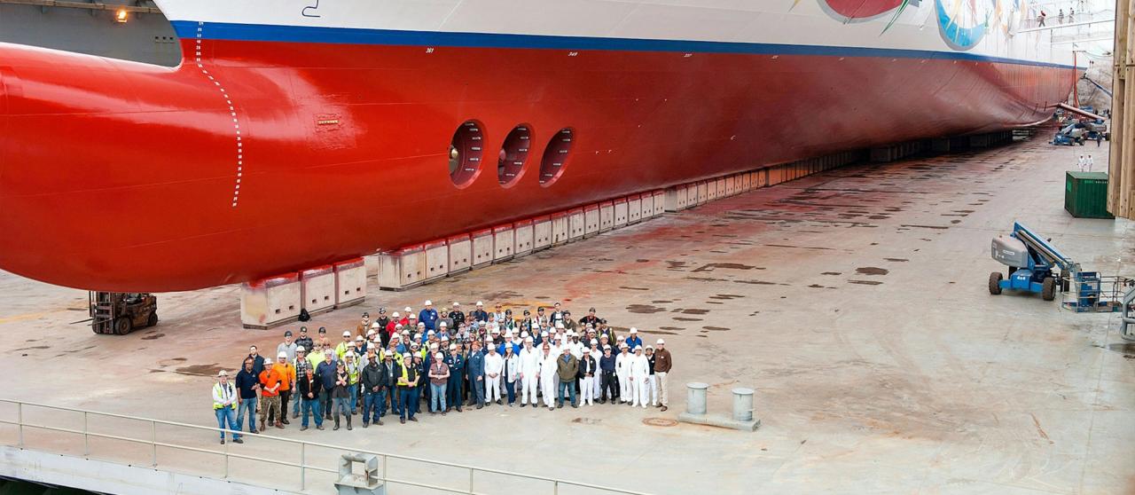 Vigor employees posing in front of a cruise ship