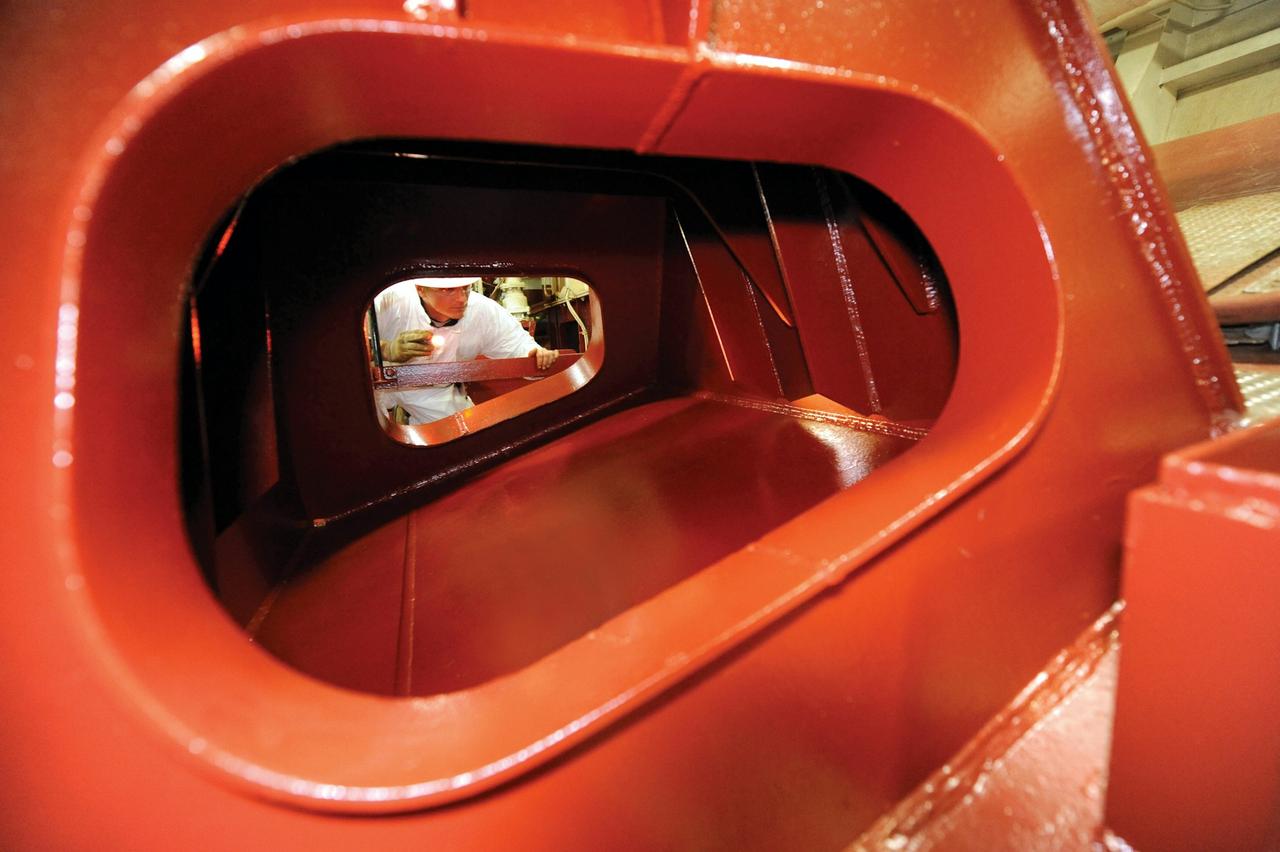 Worker putting a coating on a ship