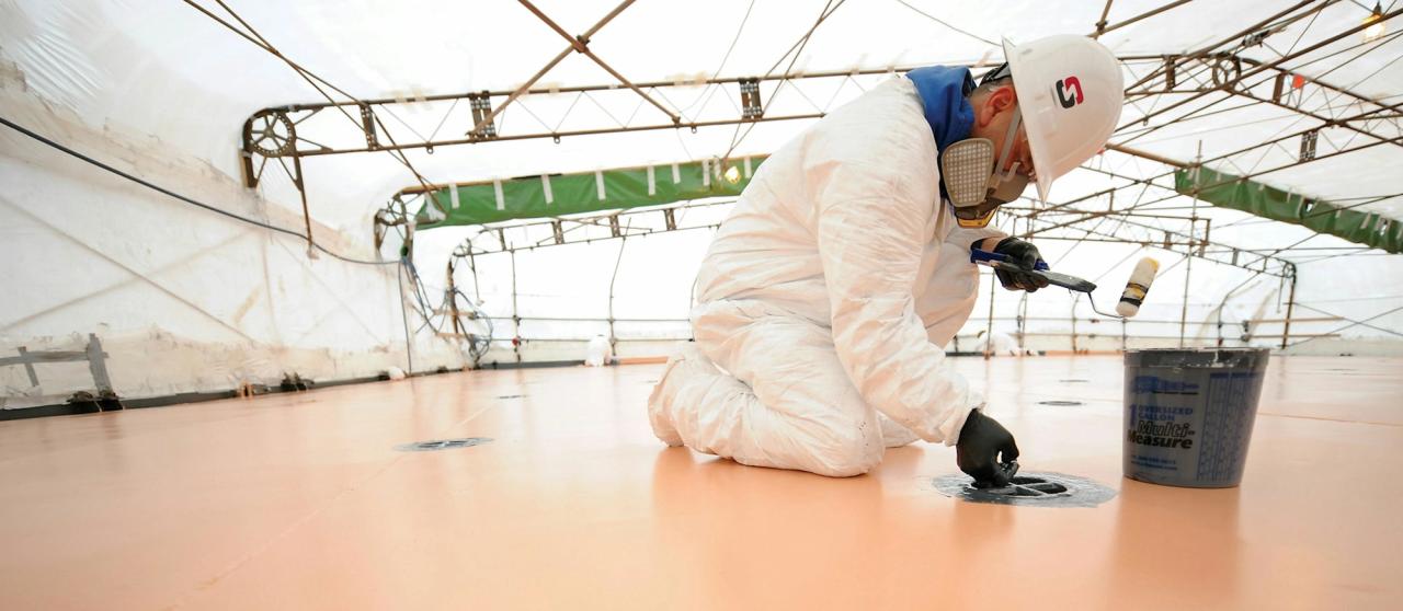 A man adding coating to a deck