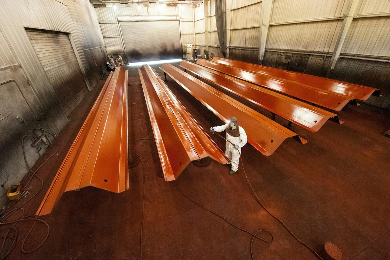 Worker applying coating on metal