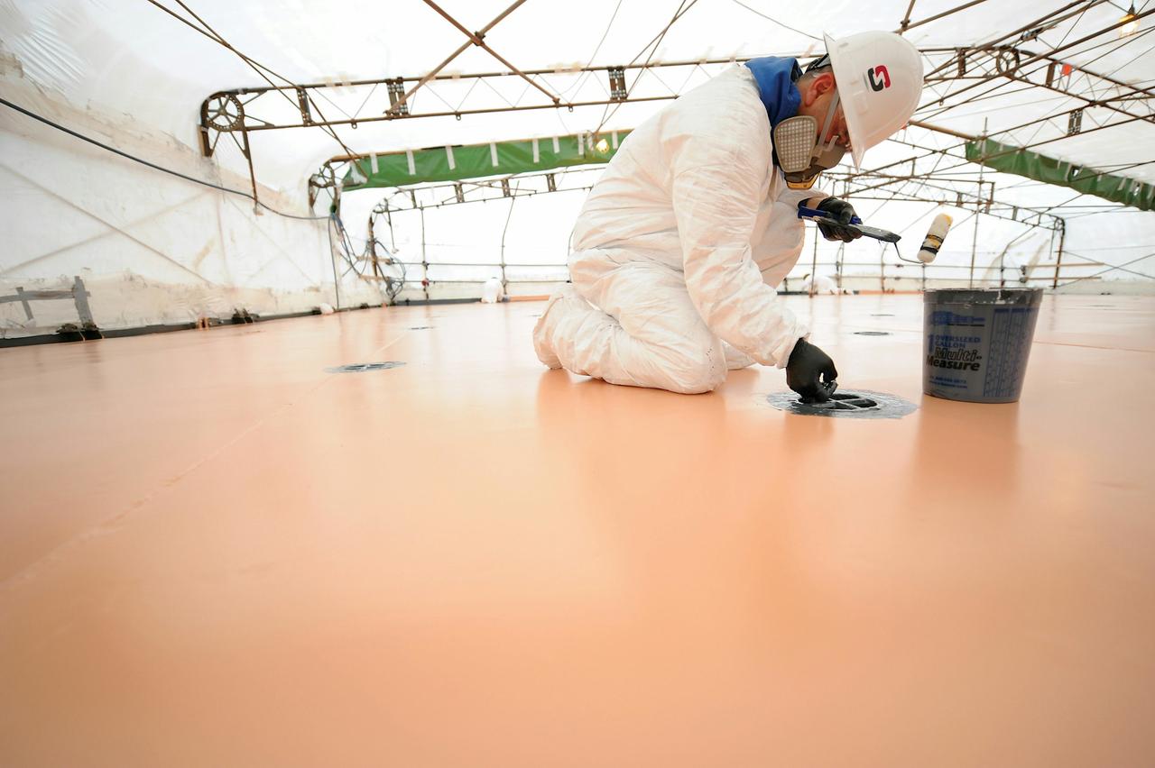 Worker adding marine coating