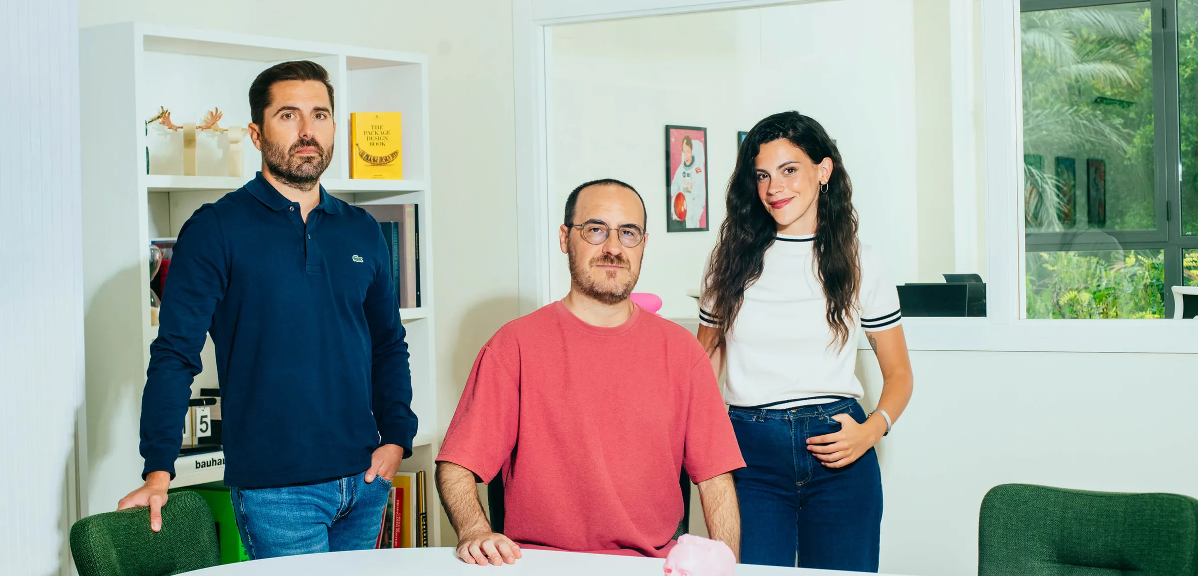 El equipo de GOMA trabajando alrededor de una mesa en la oficina.