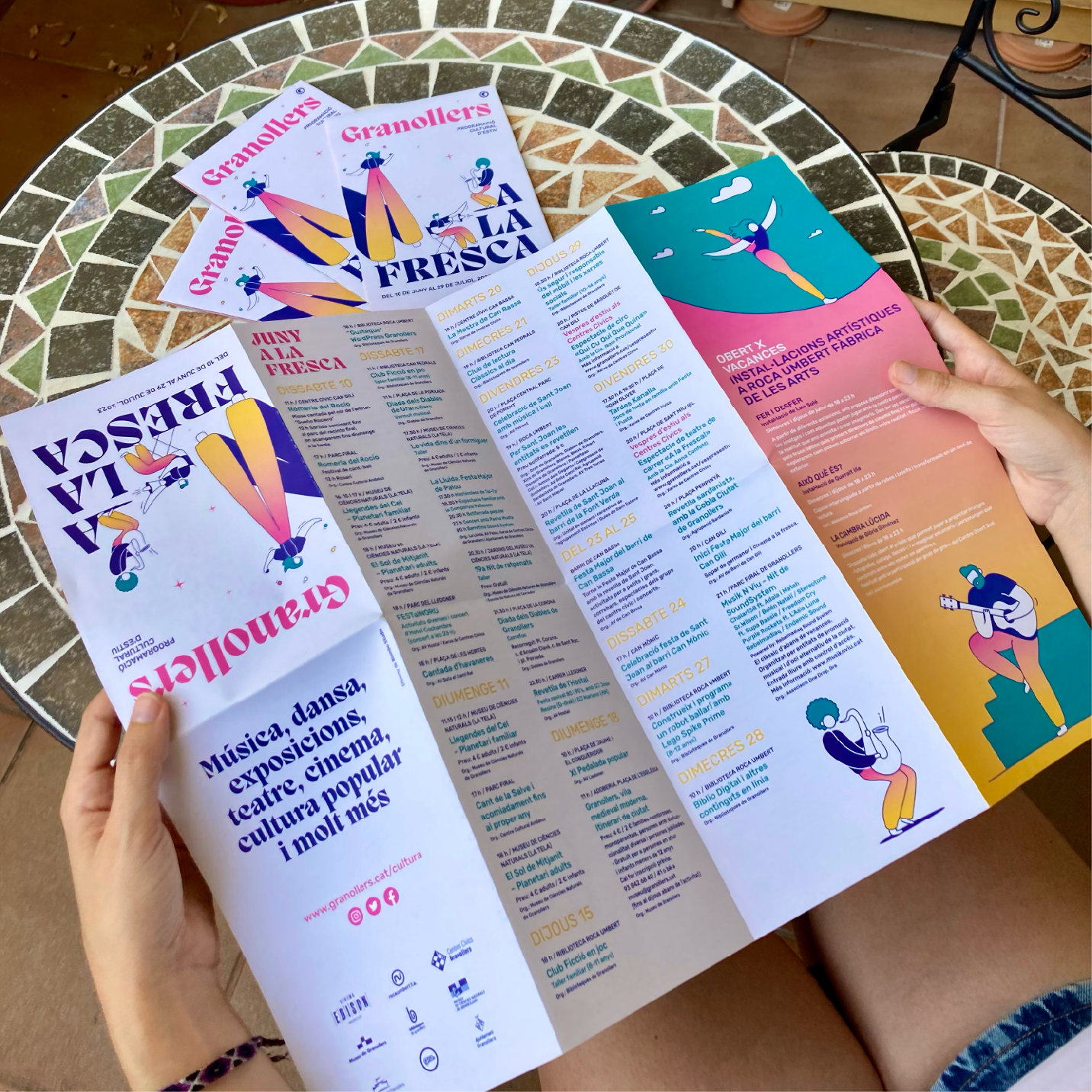 Persona llegint el programa de la campanya "Granollers a la fresca" de Biombo Studio