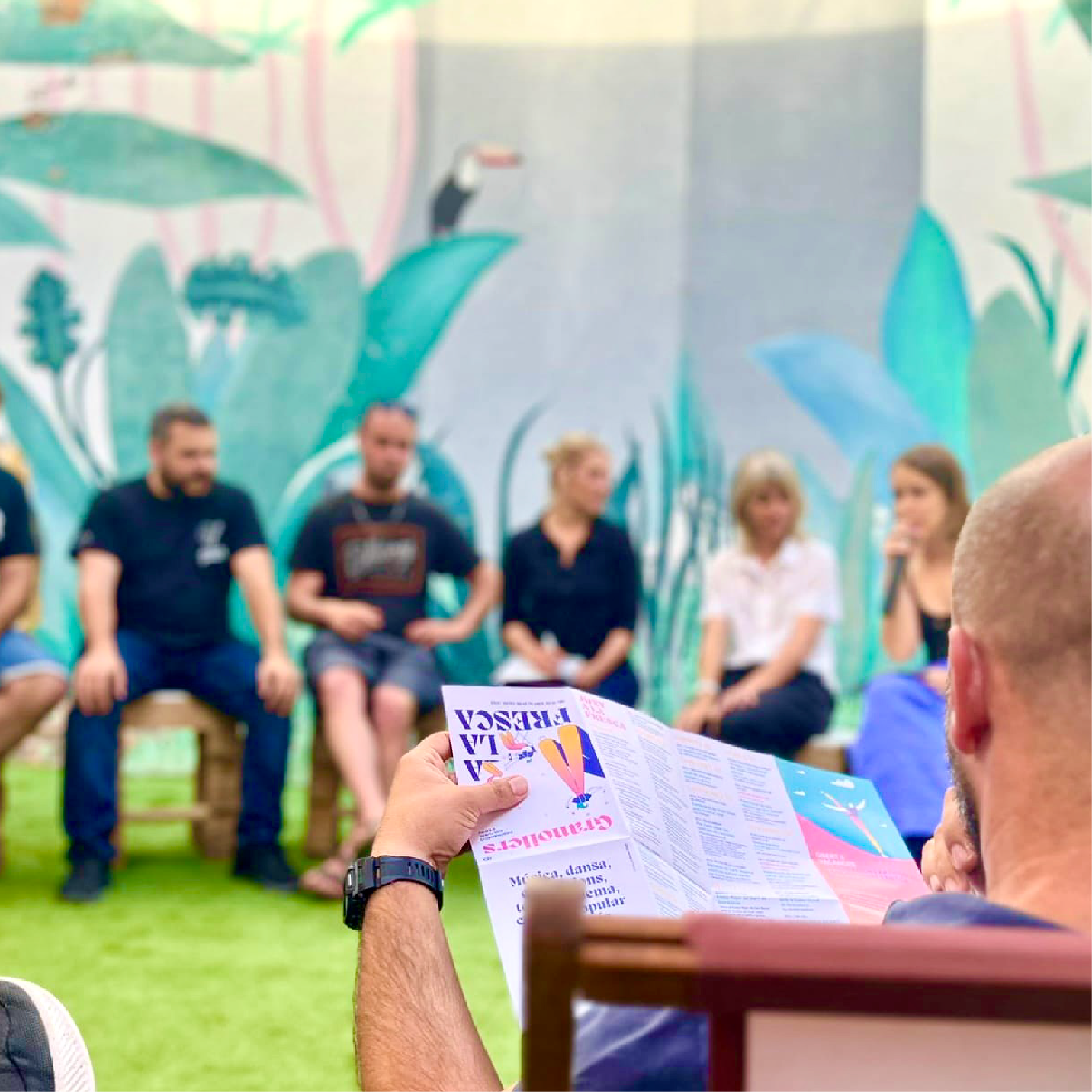 Persona llegint el programa de la campanya "Granollers a la fresca" de Biombo Studio