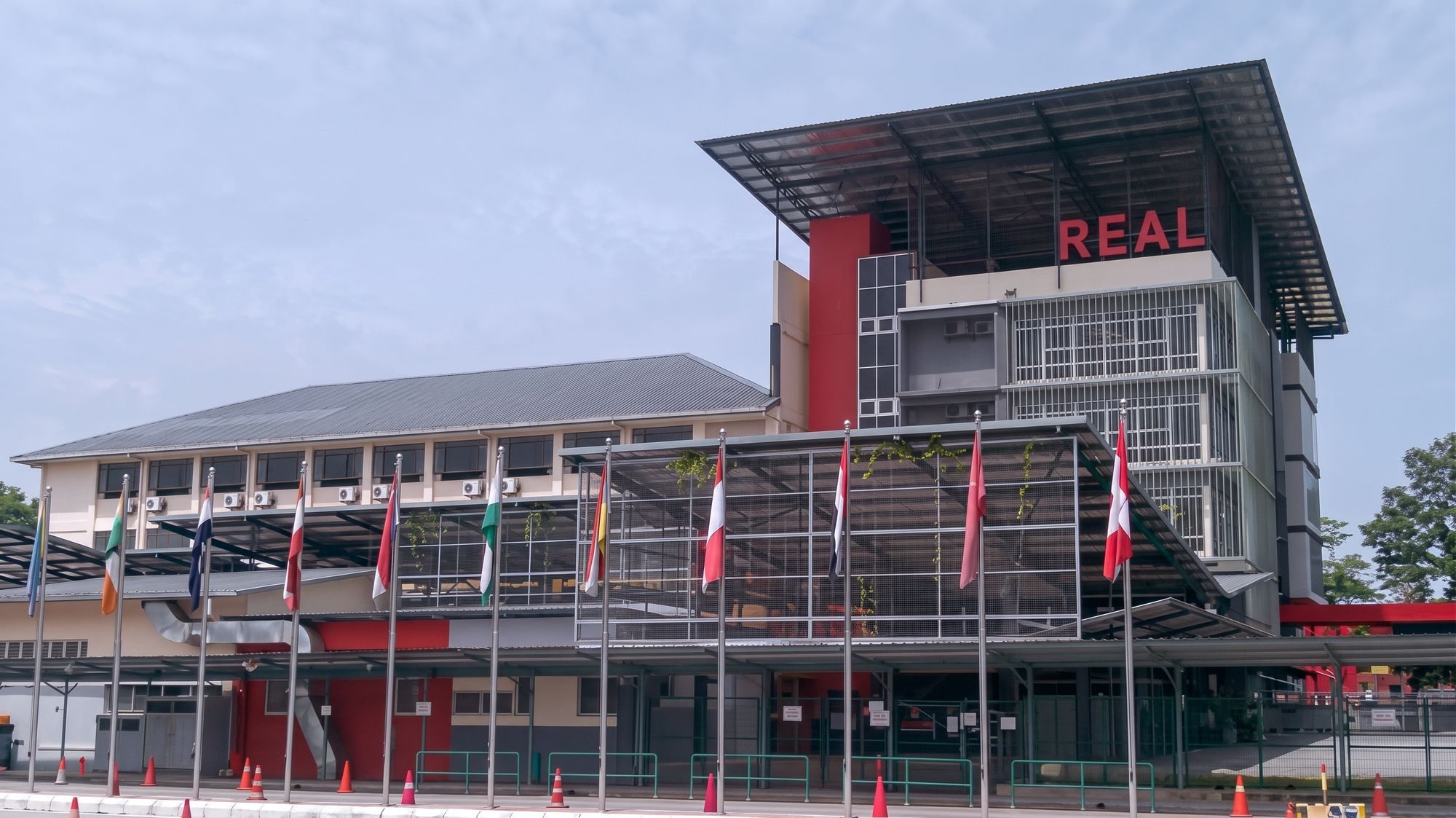 International School, Shah Alam — main entrance with the REAL tower and flag row