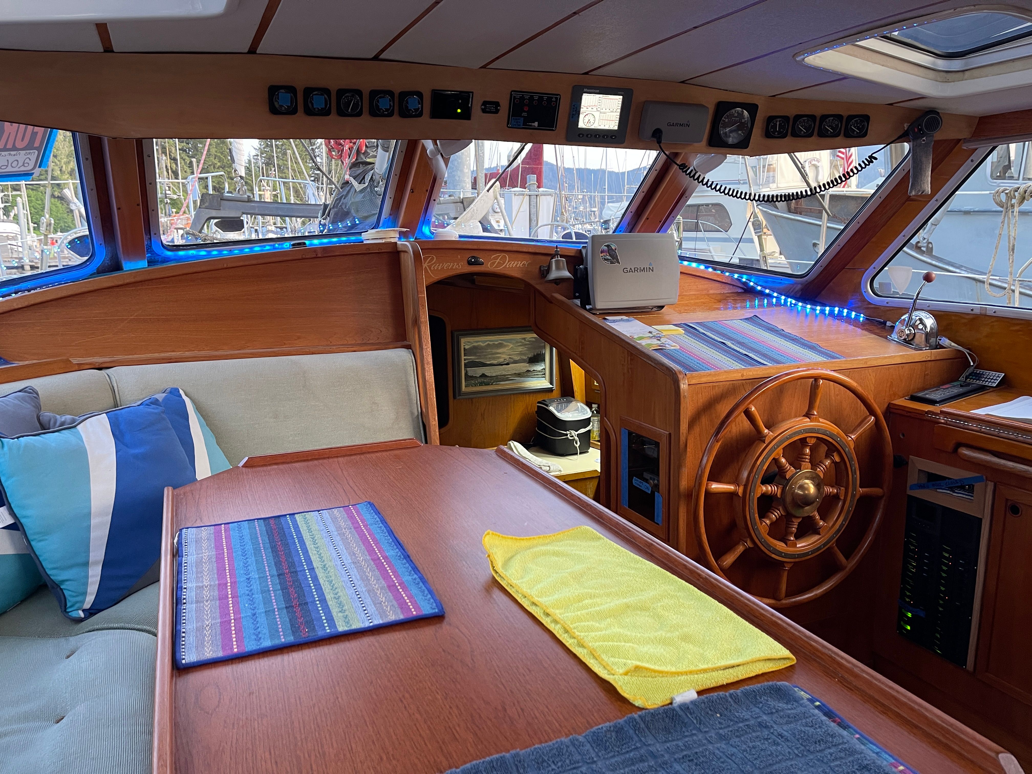 Warm wood interior of the pilothouse with navigation wheel and seating