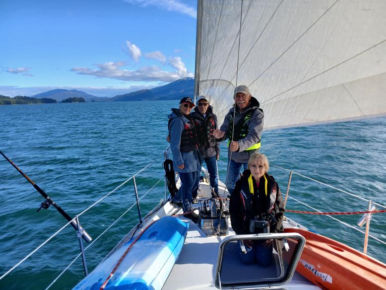 Four passengers on a sailboat deck